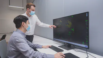 Mr Abraham Noah Wu (left) and Dr Filip Biljecki (right) showing the features of Roofpedia, an automated tool that they had developed, which uses satellite images to track solar and green roof penetration. Credit: NUS.